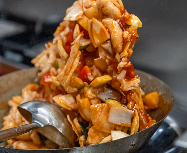 Stir-fried vegetables and chicken lifted from a hot wok.